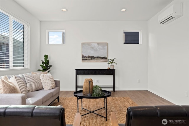 living area with recessed lighting, baseboards, wood finished floors, and a wall mounted AC