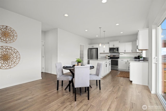 dining room with light wood-style flooring and recessed lighting