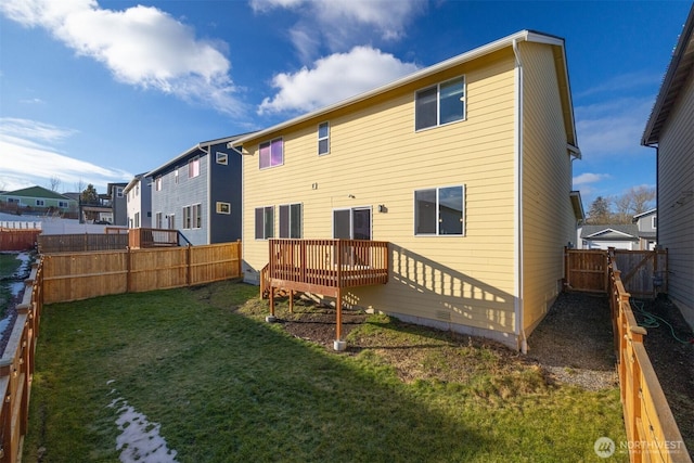 rear view of property with a deck, a lawn, a fenced backyard, and a residential view