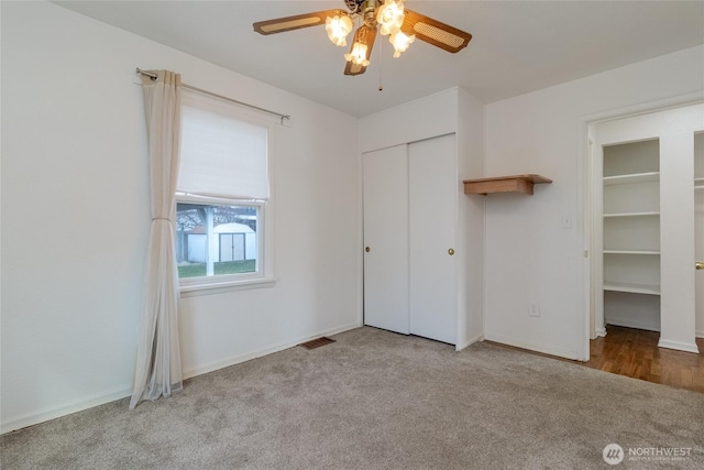 unfurnished bedroom with light carpet, baseboards, visible vents, a ceiling fan, and a closet