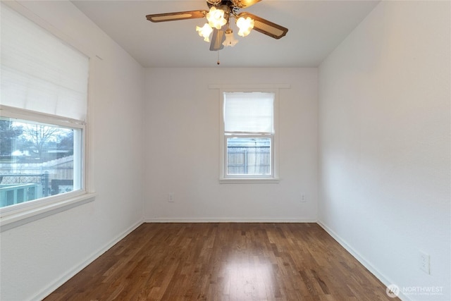 empty room featuring plenty of natural light, baseboards, ceiling fan, and dark wood-style flooring