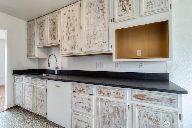 kitchen featuring dark countertops, white dishwasher, and a sink