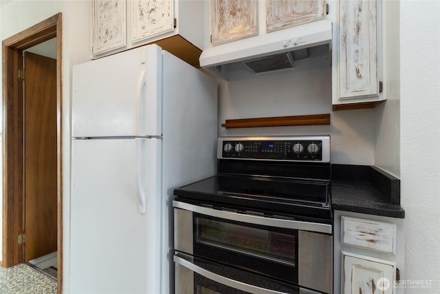 kitchen with range with two ovens, dark countertops, freestanding refrigerator, and under cabinet range hood