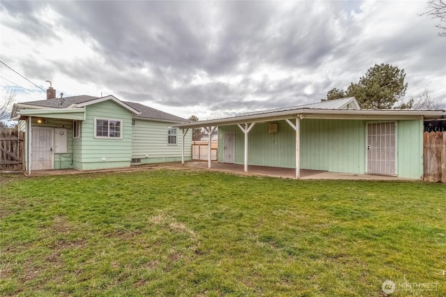 back of property with a patio, a lawn, and fence