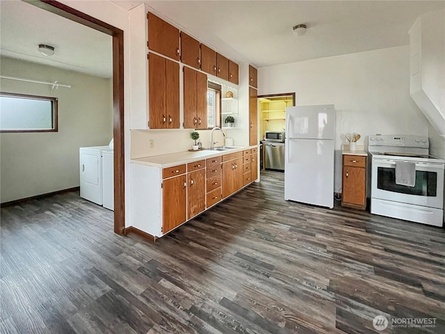 kitchen with brown cabinets, washing machine and clothes dryer, light countertops, a sink, and white appliances