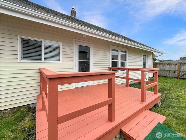 wooden deck featuring a lawn and fence