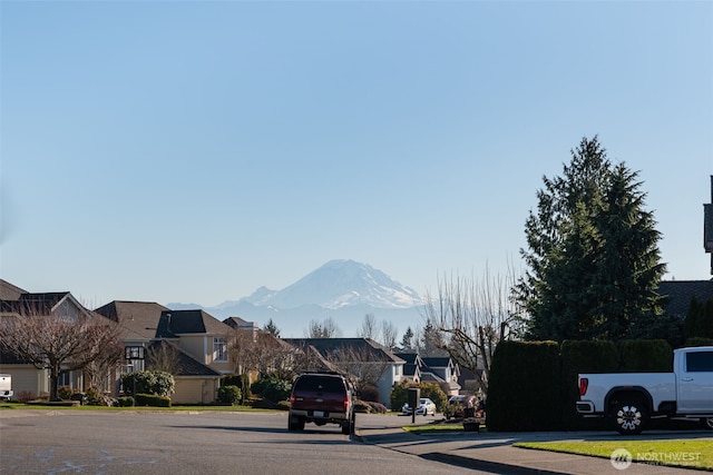 view of street featuring a residential view, curbs, a mountain view, and sidewalks