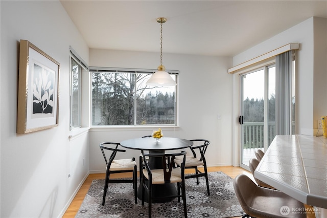 dining room with light wood-style flooring, baseboards, and breakfast area