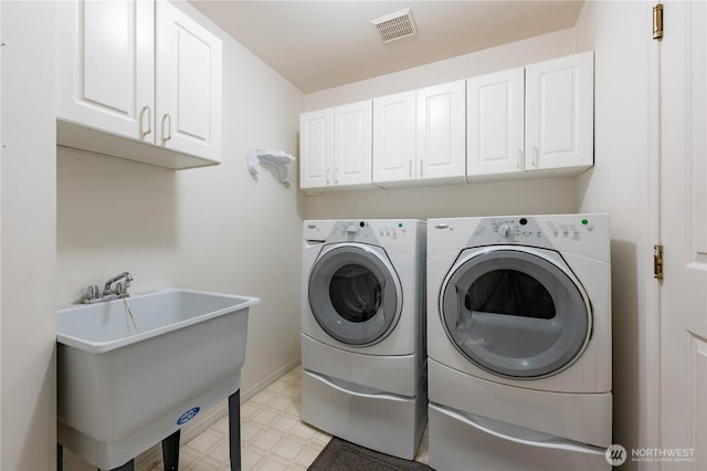 laundry room with a sink, visible vents, independent washer and dryer, cabinet space, and light floors