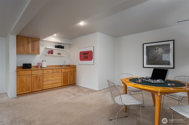 home office with light carpet, baseboards, visible vents, and a sink