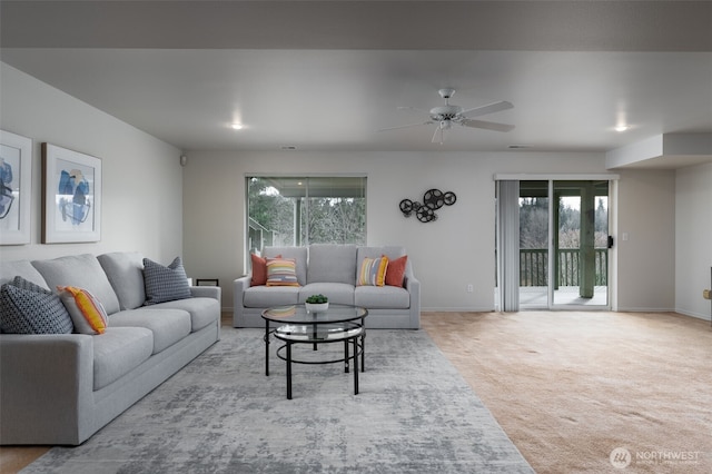 living area with carpet floors, a healthy amount of sunlight, ceiling fan, and baseboards