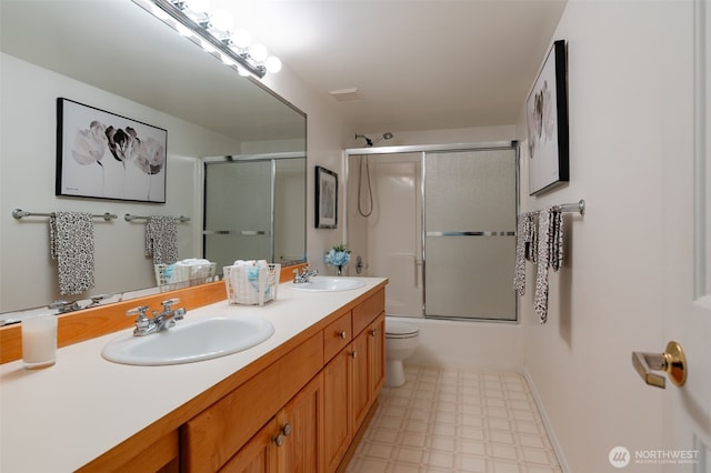 bathroom with double vanity, shower / bath combination with glass door, a sink, and tile patterned floors