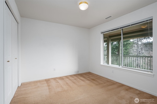 unfurnished bedroom featuring baseboards, a closet, visible vents, and carpet flooring