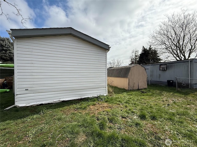 view of side of home featuring an outbuilding, a storage shed, and a yard