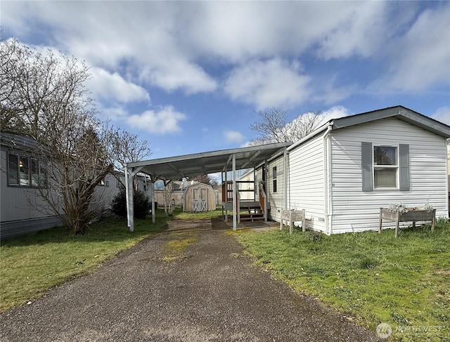 exterior space featuring an attached carport, a storage shed, and driveway