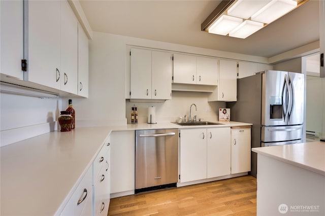 kitchen featuring white cabinetry, appliances with stainless steel finishes, light countertops, and a sink