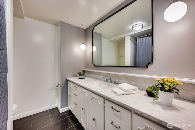 bathroom with toilet, tile patterned flooring, vanity, and baseboards