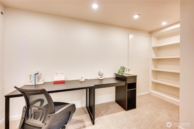 home office with baseboards, built in shelves, recessed lighting, and light colored carpet