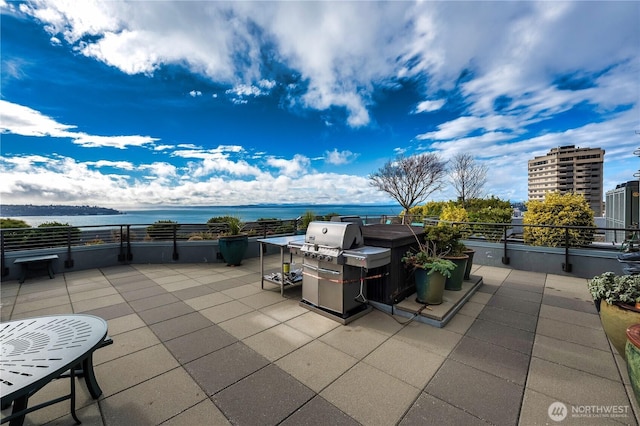 view of patio with a water view and a balcony