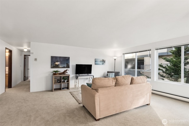 living room with a healthy amount of sunlight, baseboard heating, and light colored carpet