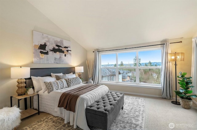 carpeted bedroom featuring lofted ceiling and baseboards