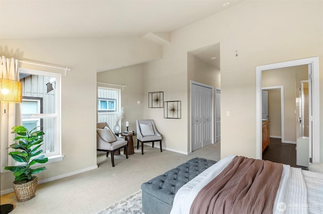 carpeted bedroom with high vaulted ceiling, ensuite bath, and baseboards