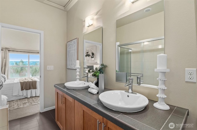 ensuite bathroom with double vanity, tile patterned flooring, a sink, and ensuite bathroom