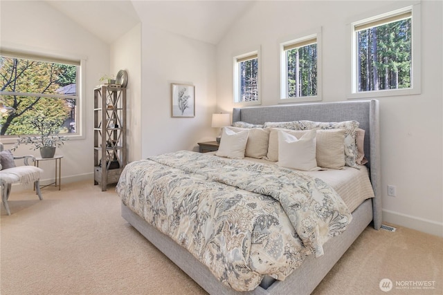 bedroom with carpet floors, multiple windows, and vaulted ceiling