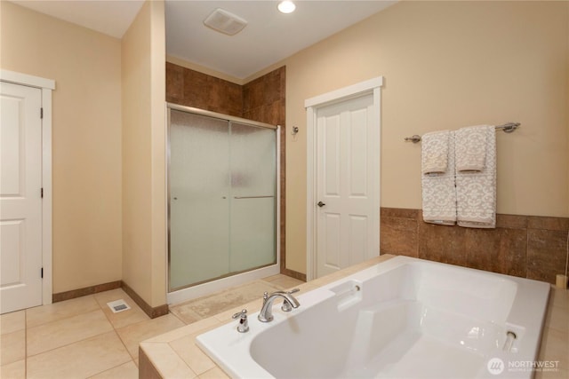 full bath featuring a stall shower, tile patterned flooring, a garden tub, and baseboards