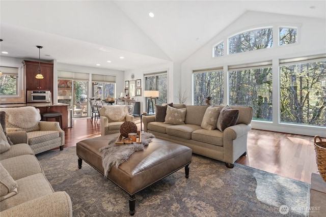 living room with high vaulted ceiling, dark wood finished floors, and recessed lighting