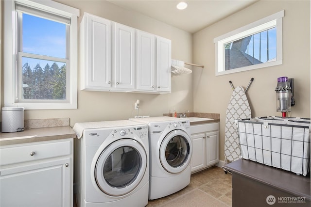 laundry room featuring cabinet space, washer and clothes dryer, and a sink