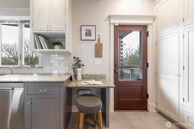 interior space featuring light stone counters, open shelves, backsplash, gray cabinetry, and white cabinetry