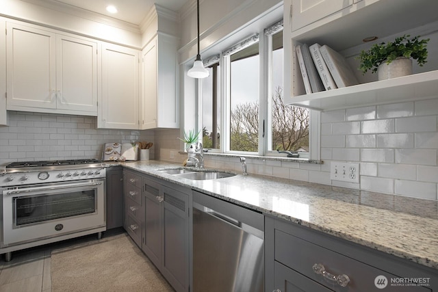 kitchen with a sink, white cabinets, hanging light fixtures, appliances with stainless steel finishes, and open shelves