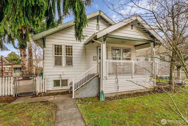 bungalow with a gate, a front lawn, a porch, and fence