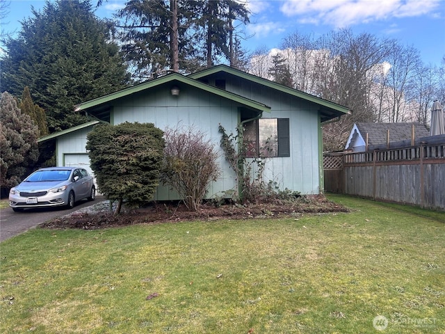 view of property exterior with a garage and a lawn