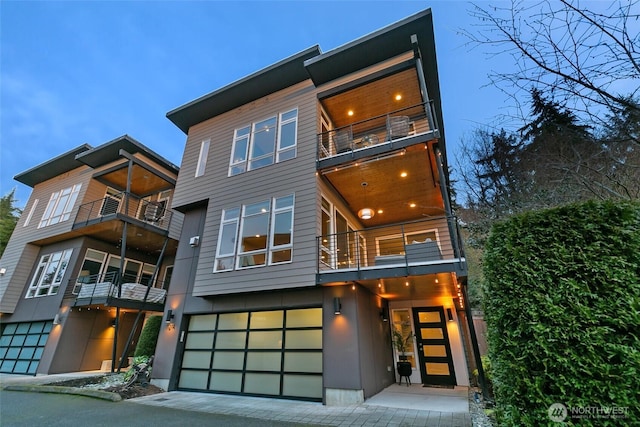 contemporary home with an attached garage and a balcony