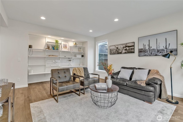 living area featuring light wood-style floors, baseboards, and recessed lighting