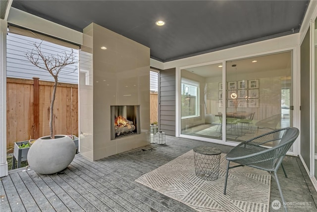 view of patio featuring a fireplace and fence