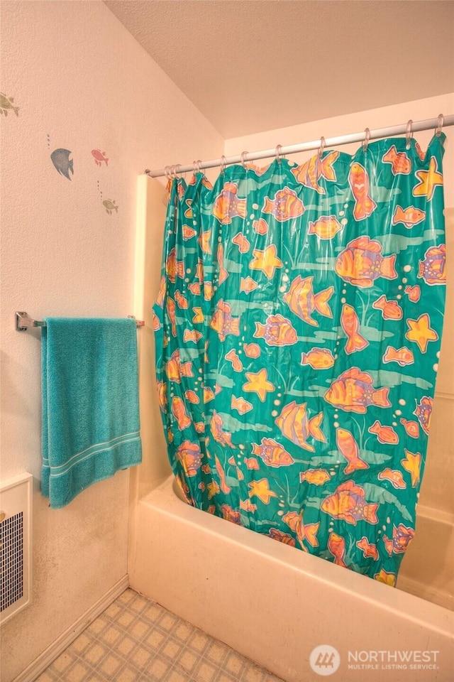 bathroom featuring shower / bathtub combination with curtain