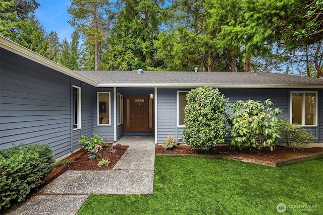 entrance to property featuring a lawn