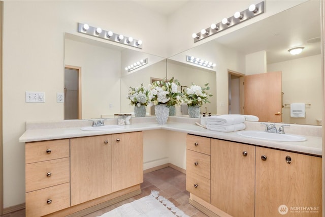 full bathroom with a sink, double vanity, and tile patterned floors