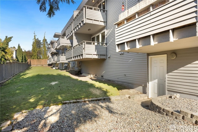 view of property exterior with fence and a lawn