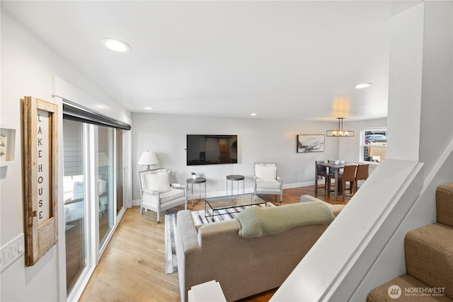 living room with stairs, recessed lighting, baseboards, and light wood-style floors