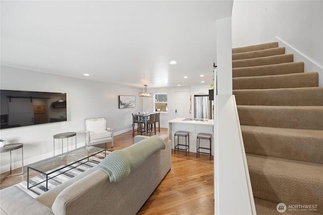 living area with stairs, light wood-type flooring, baseboards, and recessed lighting