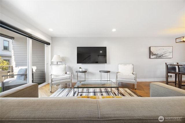 living area with light wood-type flooring, baseboards, and recessed lighting