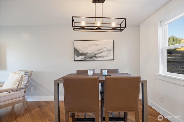 dining room with baseboards, dark wood finished floors, and an inviting chandelier