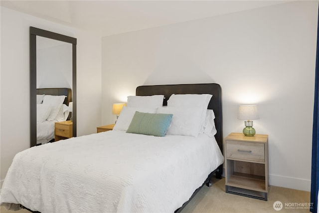 bedroom featuring light carpet and baseboards