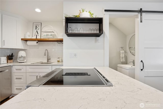 kitchen featuring open shelves, white cabinetry, a sink, light stone countertops, and dishwasher