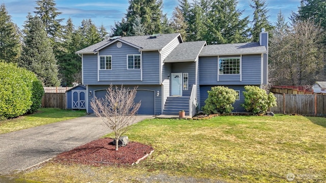 raised ranch featuring an attached garage, a chimney, fence, and concrete driveway