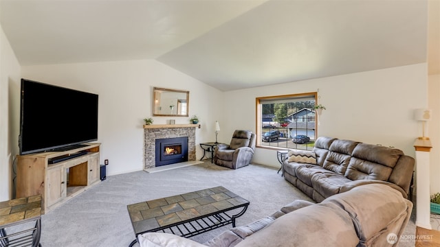 living area with lofted ceiling, carpet flooring, and a stone fireplace